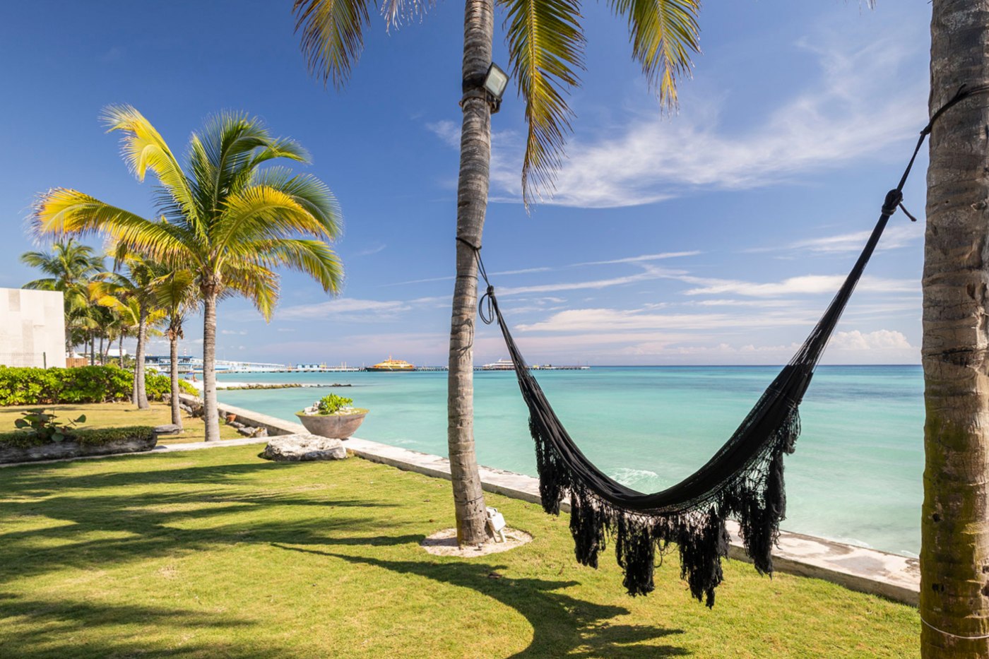 Hamaca entre palmas en un jardín frente al mar en Playacar Fase 1