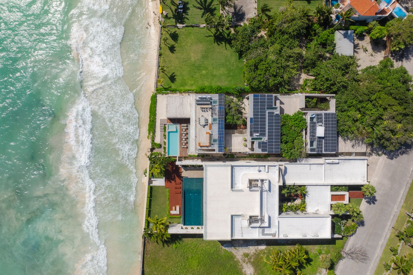 Vista aérea de paneles solares en los techos de dos casas frente al mar en Playacar Fase 1