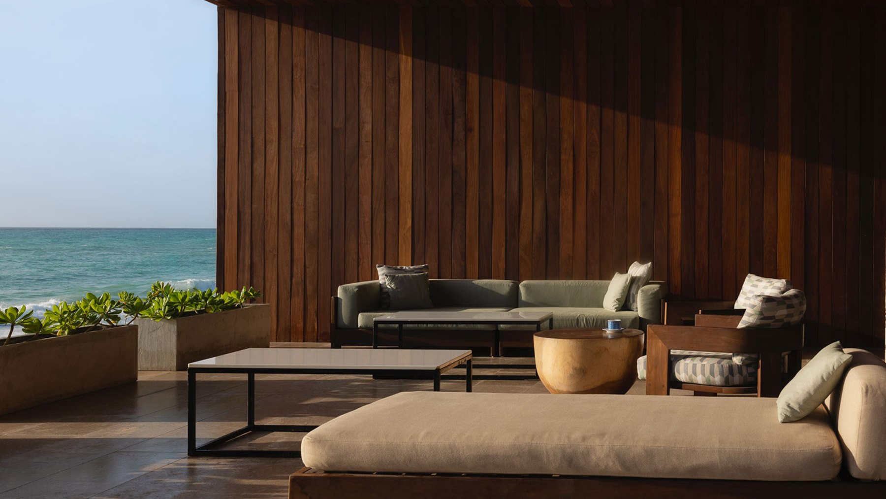 Covered terrace lounge in a Playacar Fase 1 house opening onto the sea