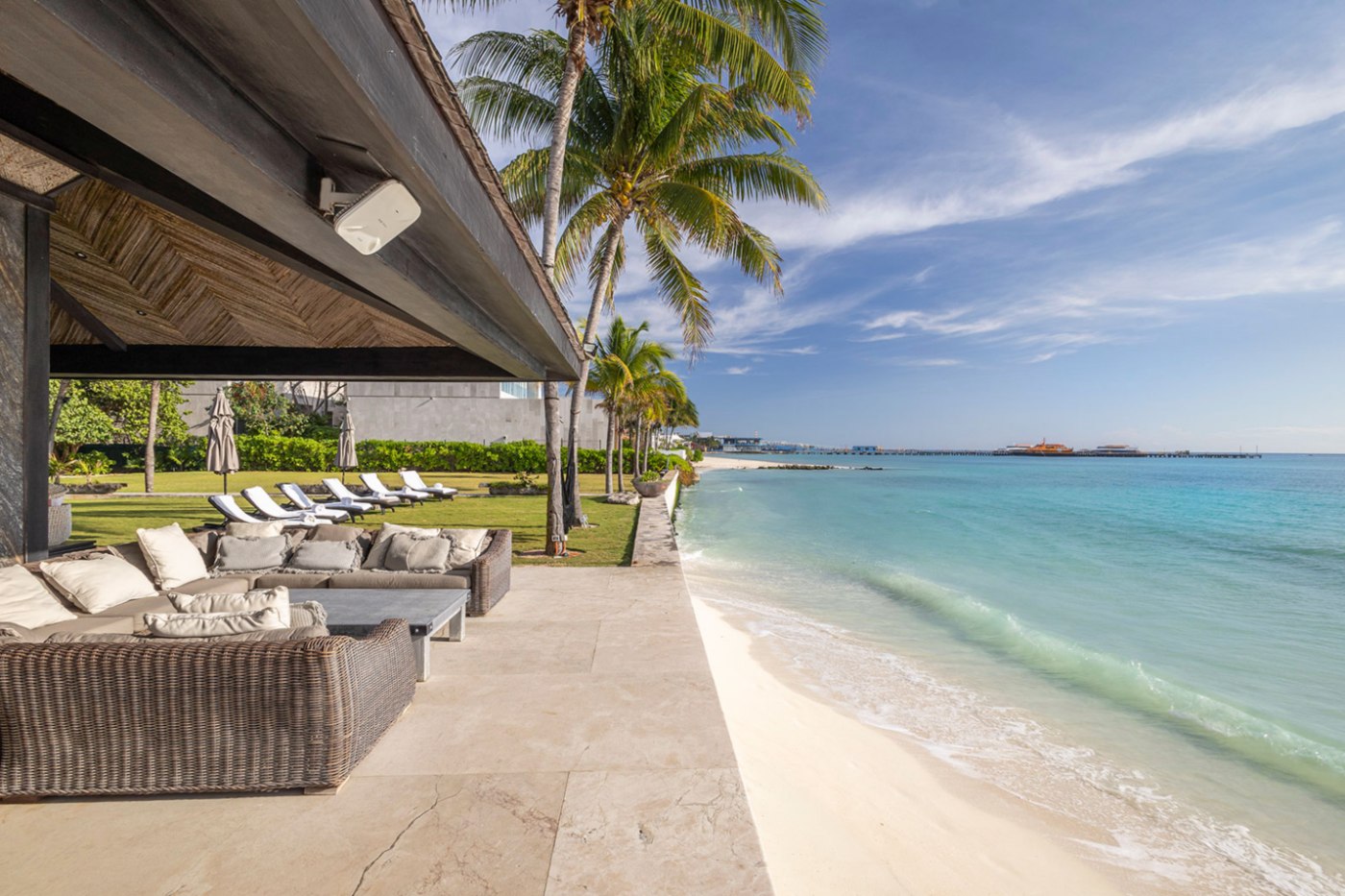 Terrasse de plage d'hôtel ombragée dans Playacar Fase 1 avec l'embarcadère de Cozumel au loin