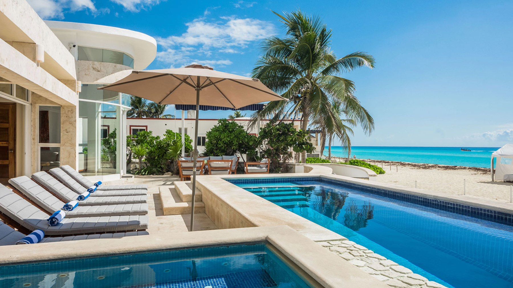 Piscine et bains de soleil dans une villa en front de mer à Playacar Fase 1, le sable à quelques pas