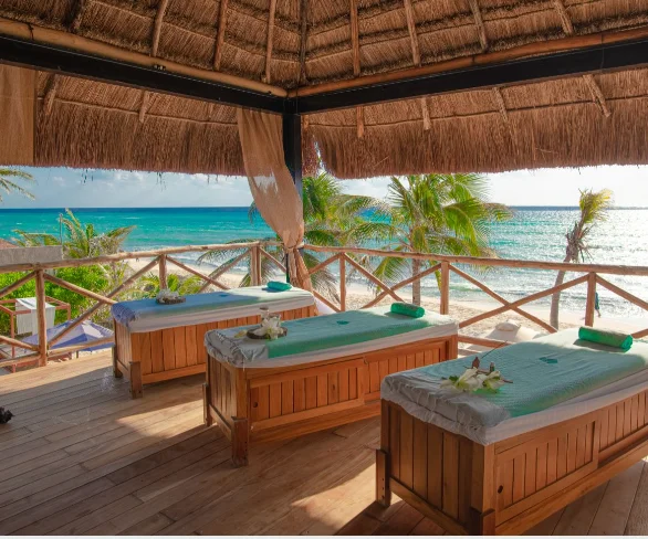 Trois tables de massage sous une palapa spa à MVNGATA, face aux Caraïbes