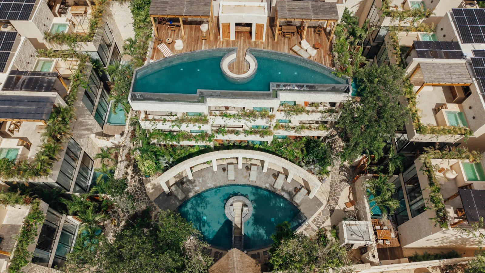 Salon d'une villa de la Riviera Maya, canapés de lin, plafond de bois et baie vitrée sur la terrasse