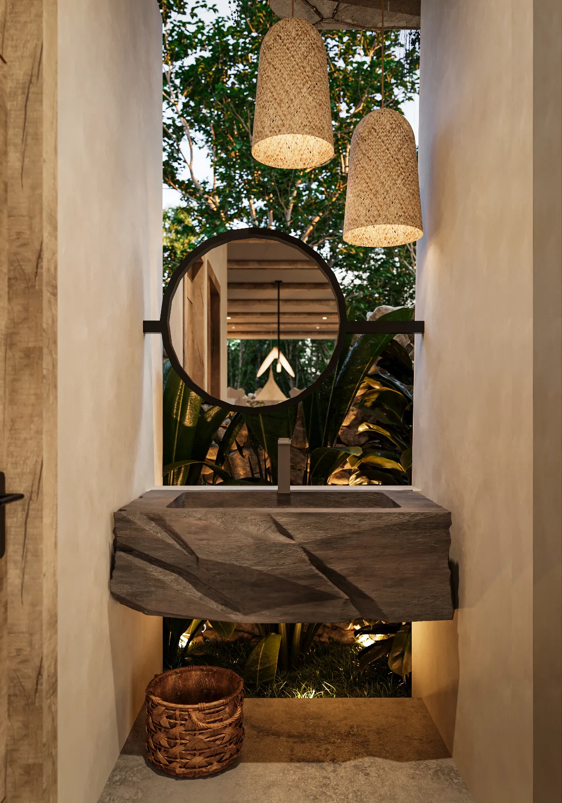 Powder room of a Riviera Maya house with a carved stone sink, round mirror and tropical garden behind