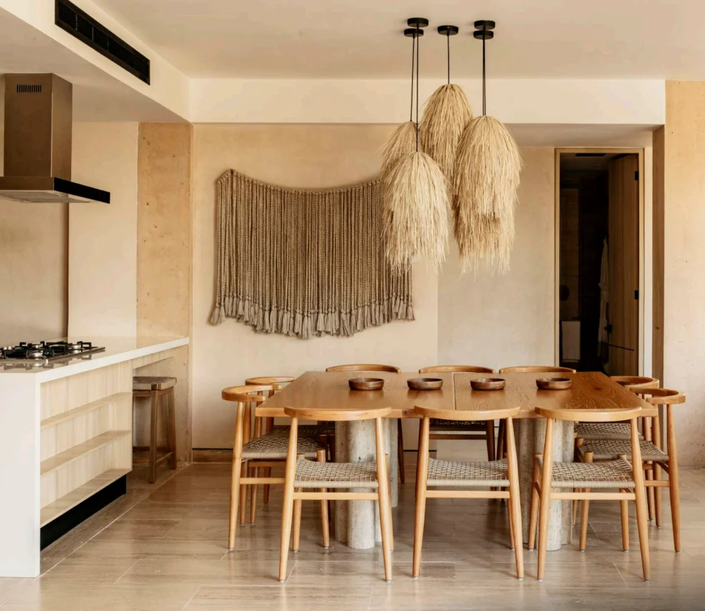 Dining room and kitchen of an apartment at The Village, Corasol, oak table under woven pendant lights