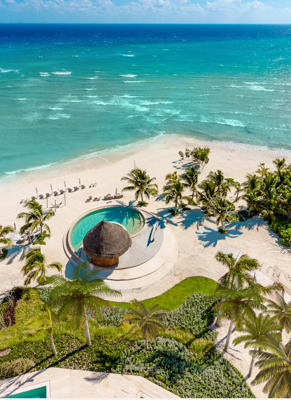 Aerial of the Costa Beach Club palapa and round pool on the white sand beach at Corasol