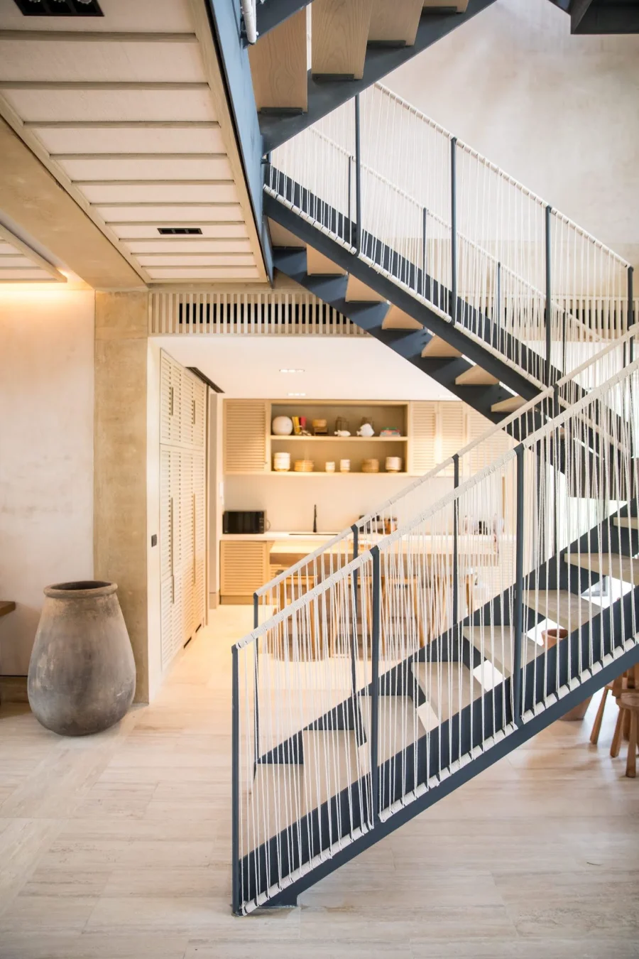 Steel and timber stair with woven rope balustrade inside a Palm Villas estate home at Corasol
