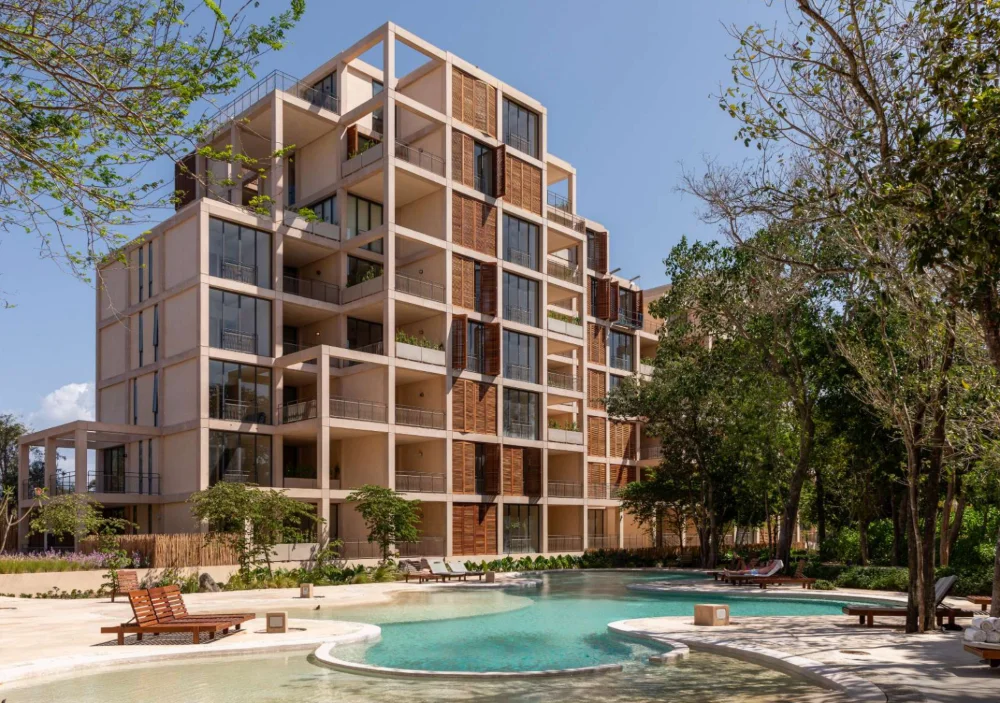 Delivered building at The Village, Corasol, timber louvres and planted balconies above the free form pool