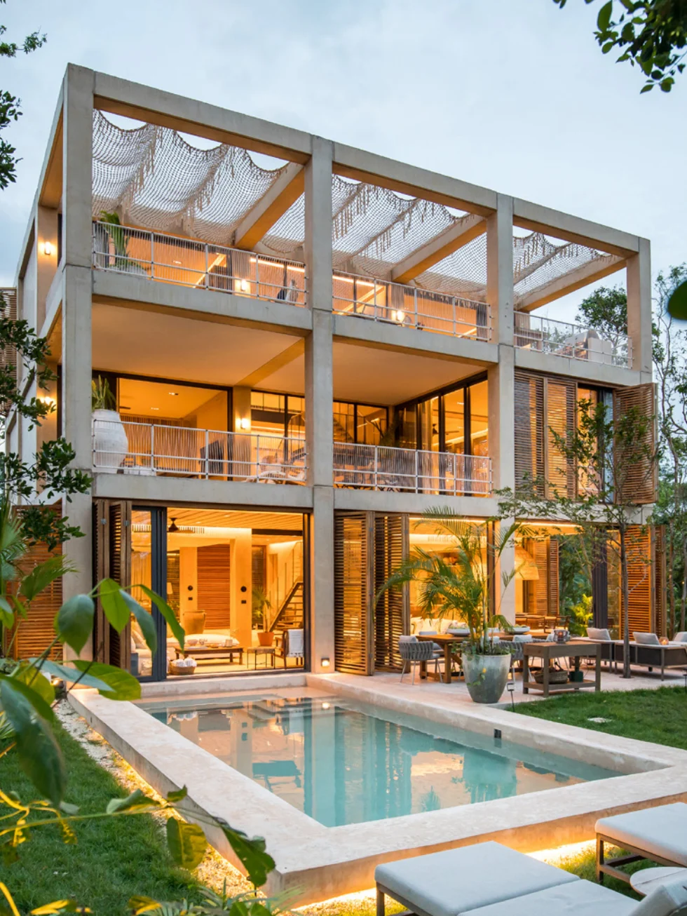 Palm Villas estate home at Corasol lit at dusk, private pool in front