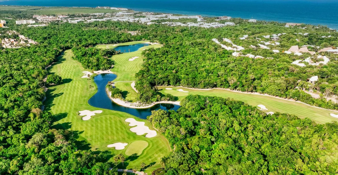 Aerial of the Gran Coyote golf course lakes at Corasol with the Caribbean and Playa del Carmen behind