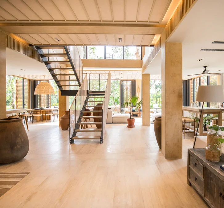 Double height entry hall of a Palm Villas estate home at Corasol, floating steel stair and open living space