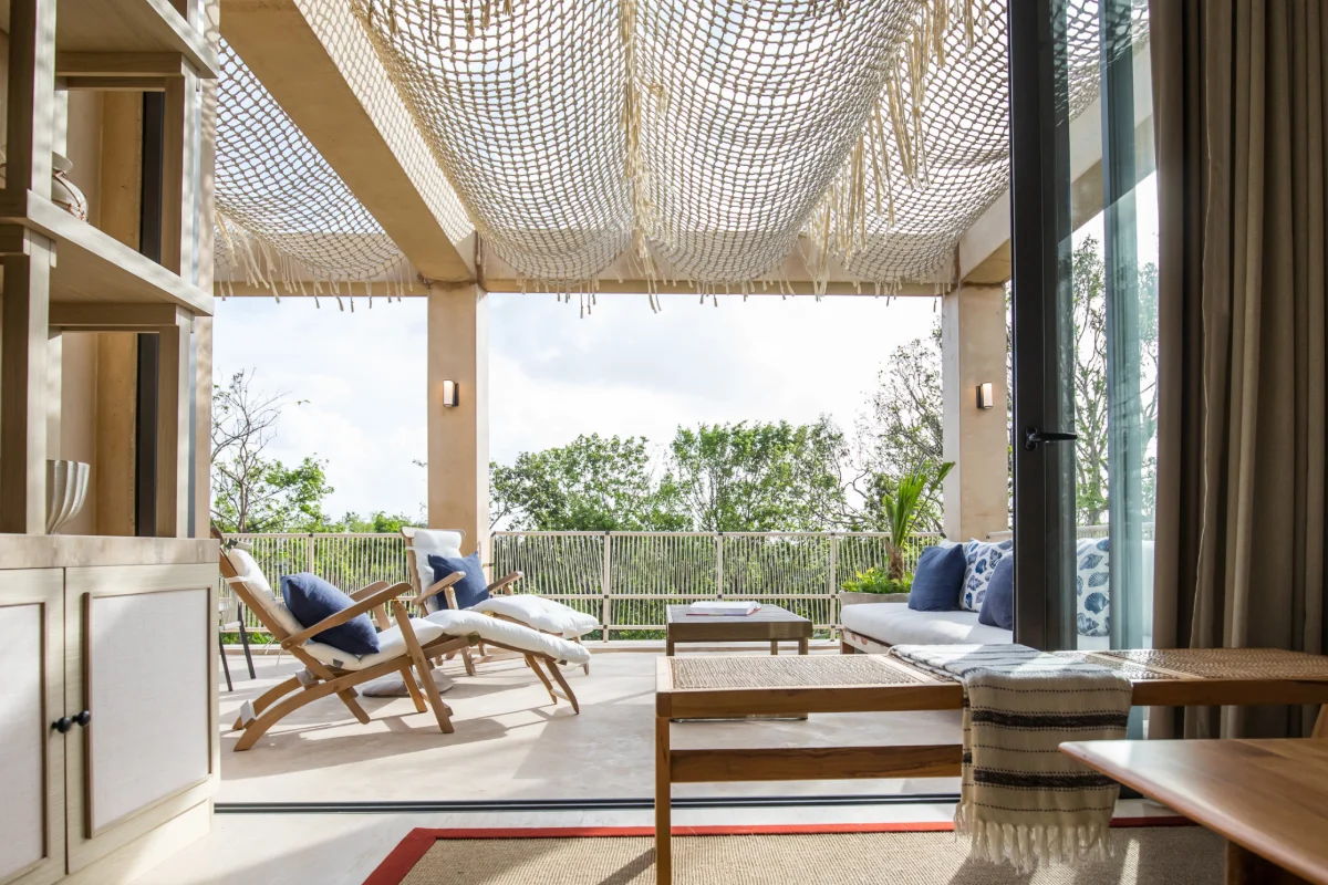 Terrasse ombragée d'une résidence de Corasol, filet suspendu, transats et vue sur la jungle