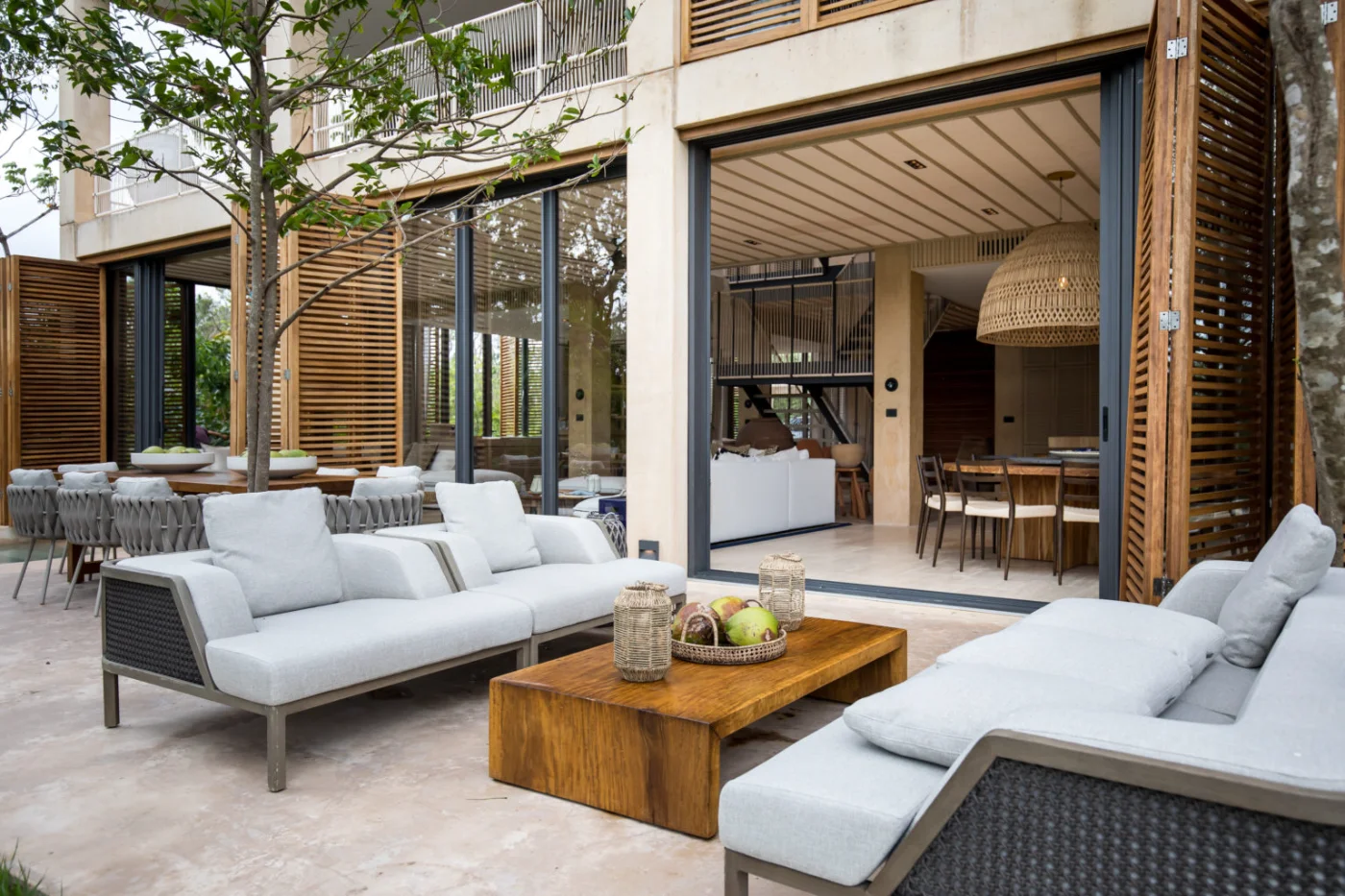 Living room and bar of a Palm Villas estate home at Corasol, travertine floors and louvred windows to the garden
