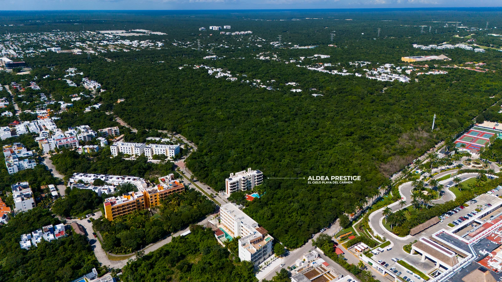 Serviced streets and open parcels still available inside El Cielo Residencial, seen from the air with the jungle around them