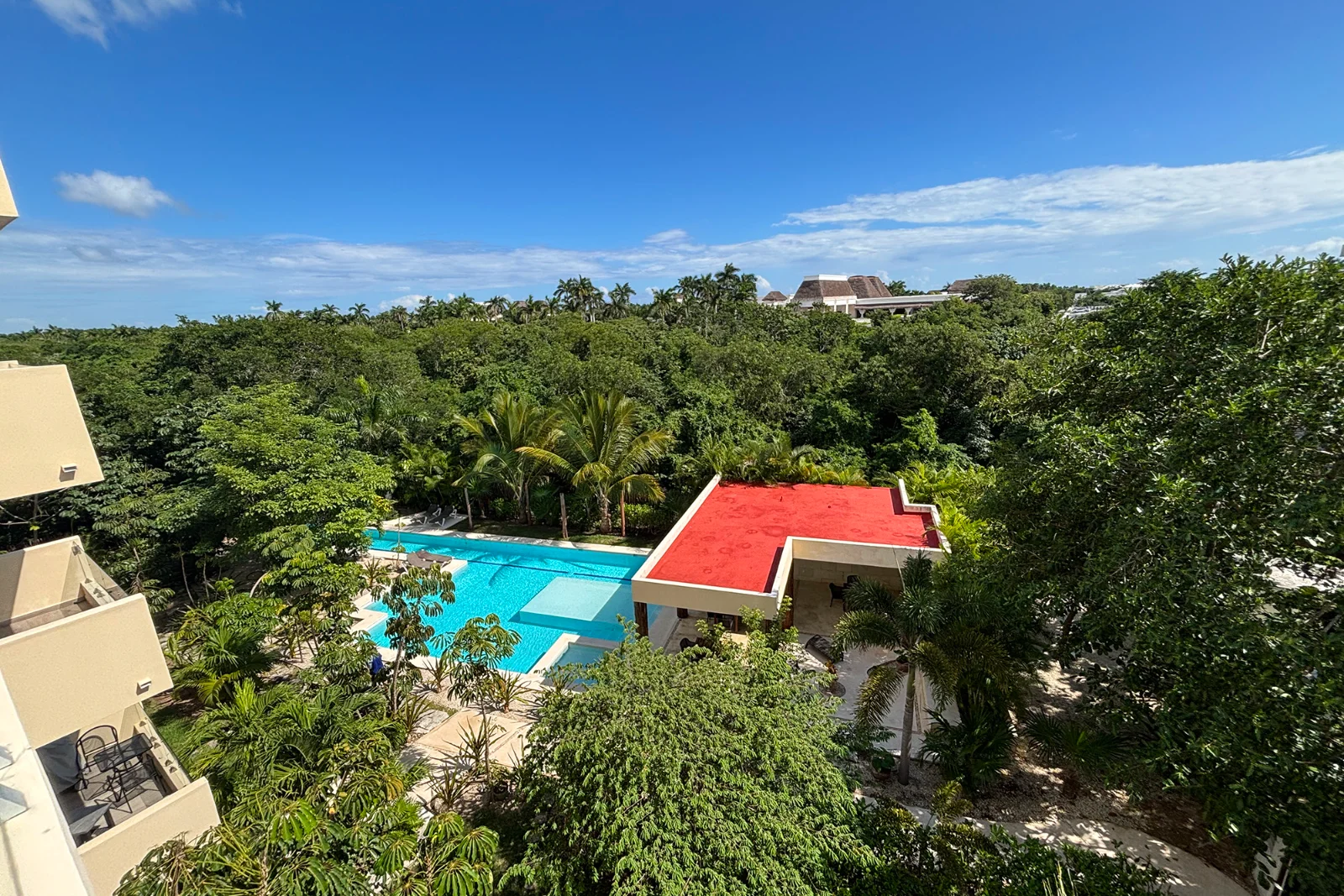 Pool, sun beds and a shaded palapa dining area in a condominium inside El Cielo Residencial