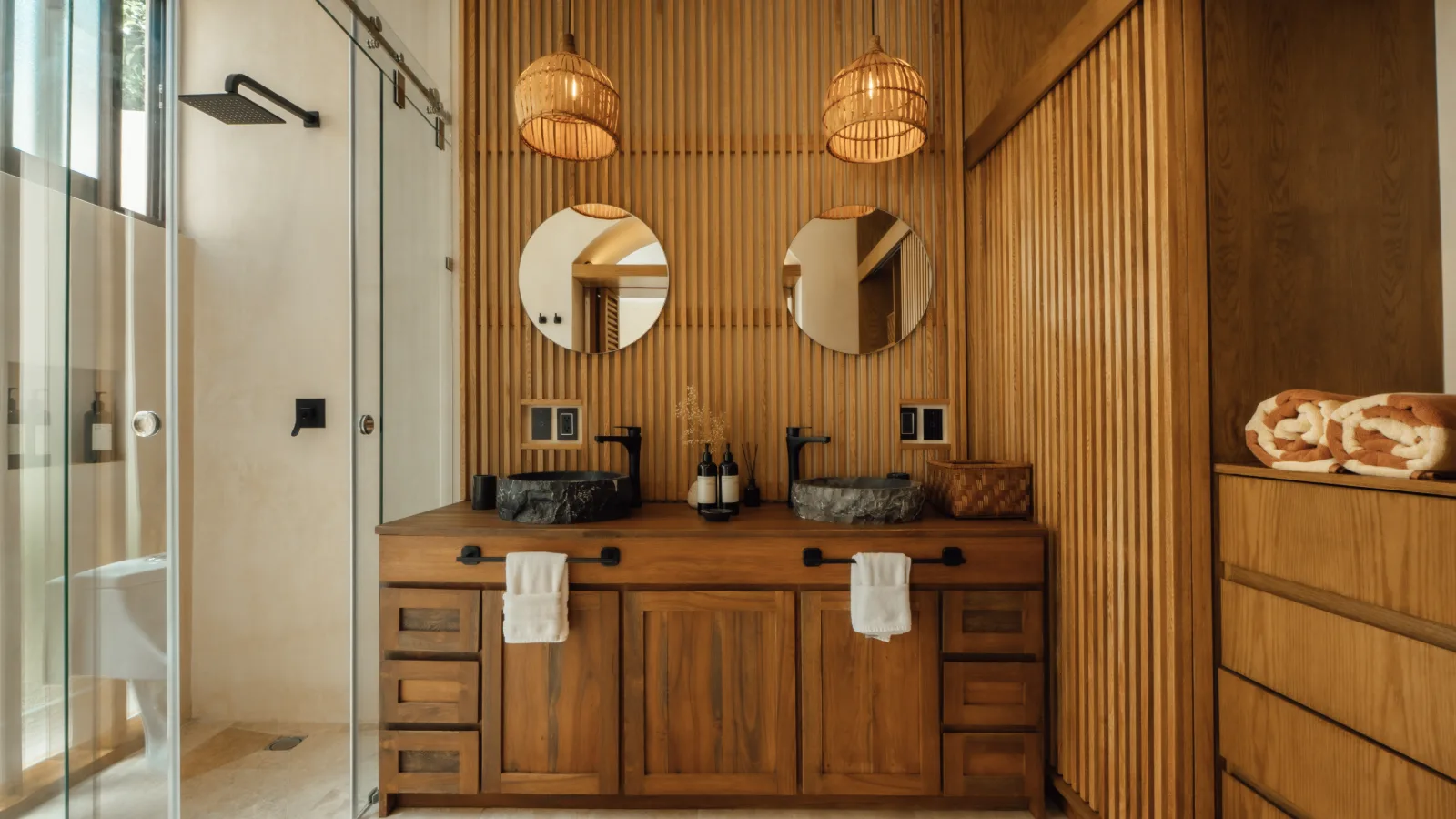 Kitchen of a Riviera Maya villa with a stone island, timber cabinetry and a breakfast bar