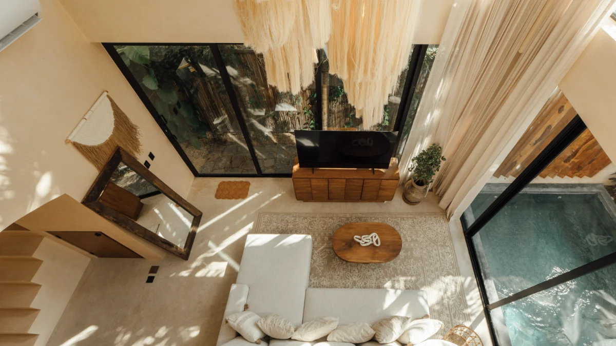 Overhead view of a real Riviera Maya villa living room, linen sofa, macrame ceiling and a private plunge pool through the glass