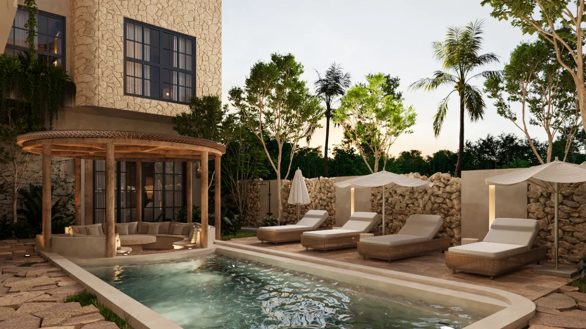 Outdoor kitchen of a Riviera Maya villa with a stainless grill, granite counter and a wall of ceramic vessels lit at dusk