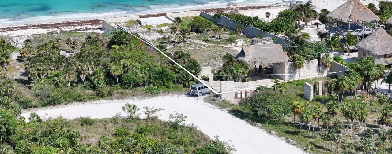 Vista aérea de un predio frente al mar en Isla Blanca con las líneas de colindancia marcadas desde el camino de arena hasta la orilla
