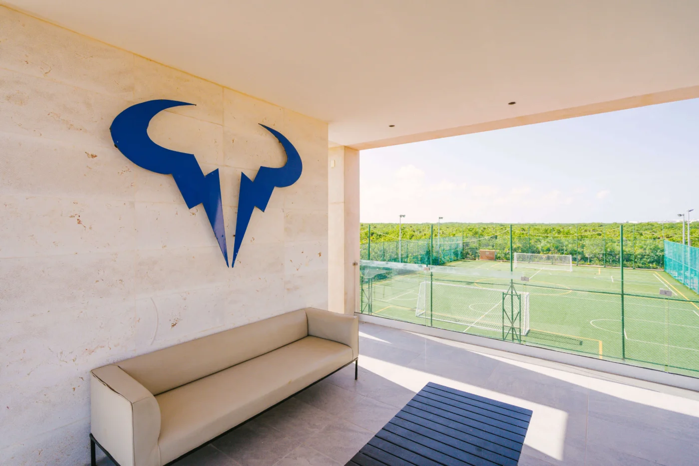 Covered lounge at the Rafa Nadal Tennis Center looking out over the multi sport pitch and the jungle beyond