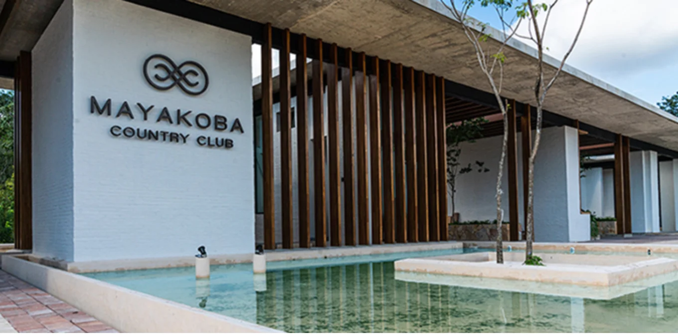 Fairway at Mayakoba Country Club with contemporary homes and palms along both sides and jungle beyond