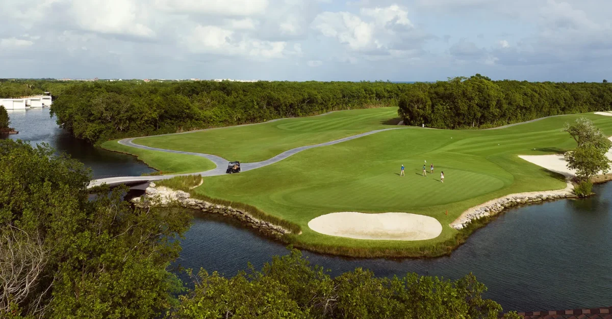 Aerial of an island green at El Camaleón ringed by limestone canal walls and mangrove