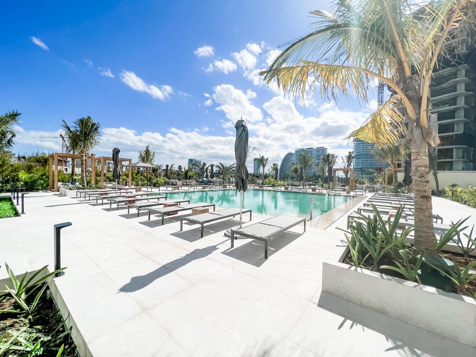 Alberca y camastros de un edificio residencial en Puerto Cancún