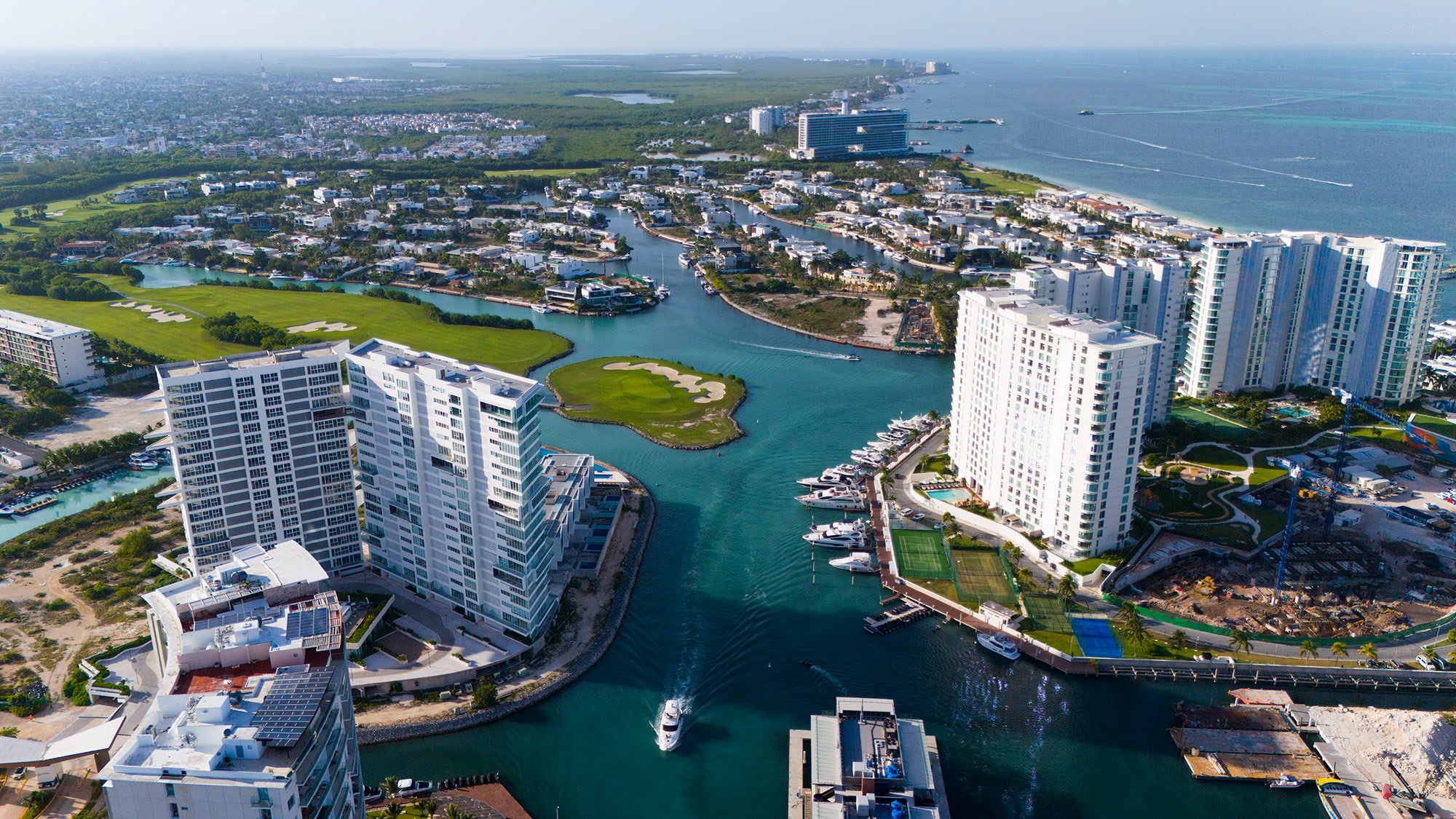 Vue aérienne des canaux de Puerto Cancún, du green en île du parcours de golf et des tours de la marina