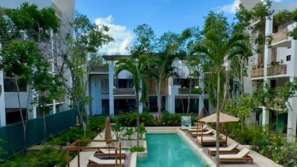 The long pool and Balinese beds between the buildings at Baikal, Tulum Country Club