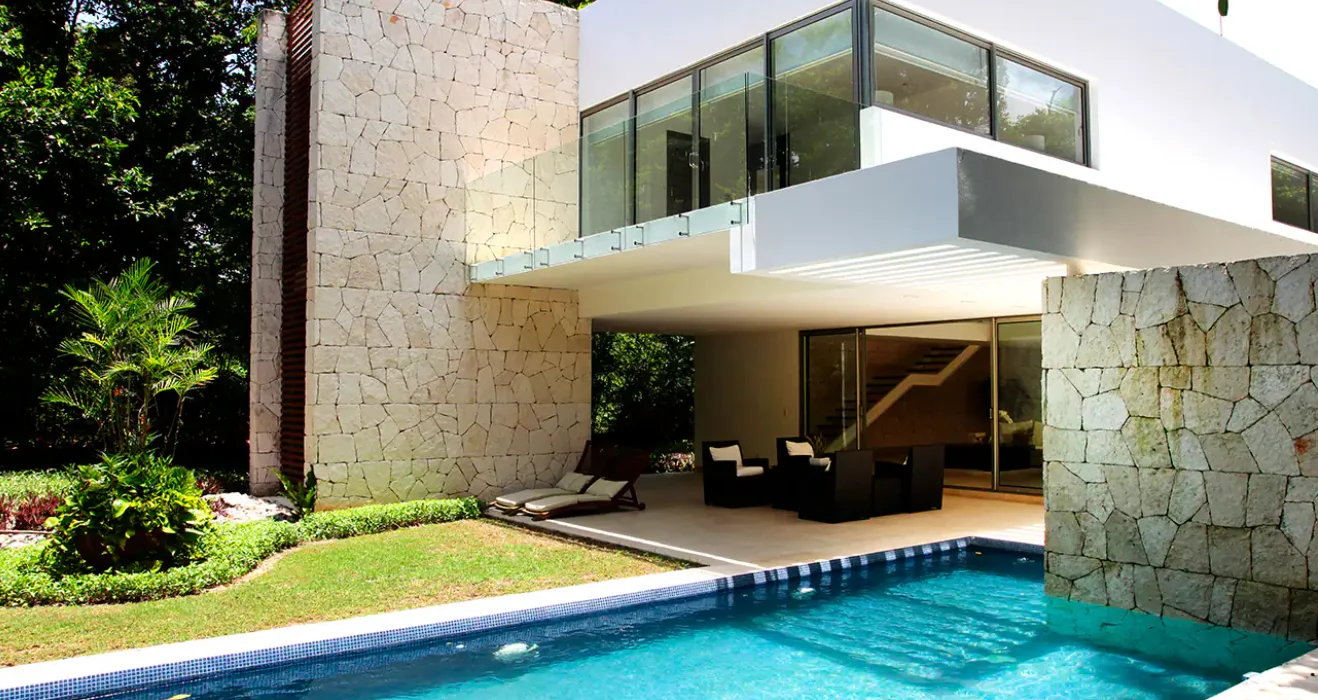 Premium Home at Tulum Country Club, stone clad volumes with a cantilevered upper floor, covered terrace and private pool against the jungle